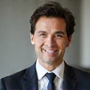 Ritratto professionale di un uomo sorridente, capelli scuri, abito elegante