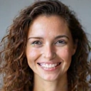 Ritratto professionale di una donna sorridente, capelli ricci, sorriso amichevole